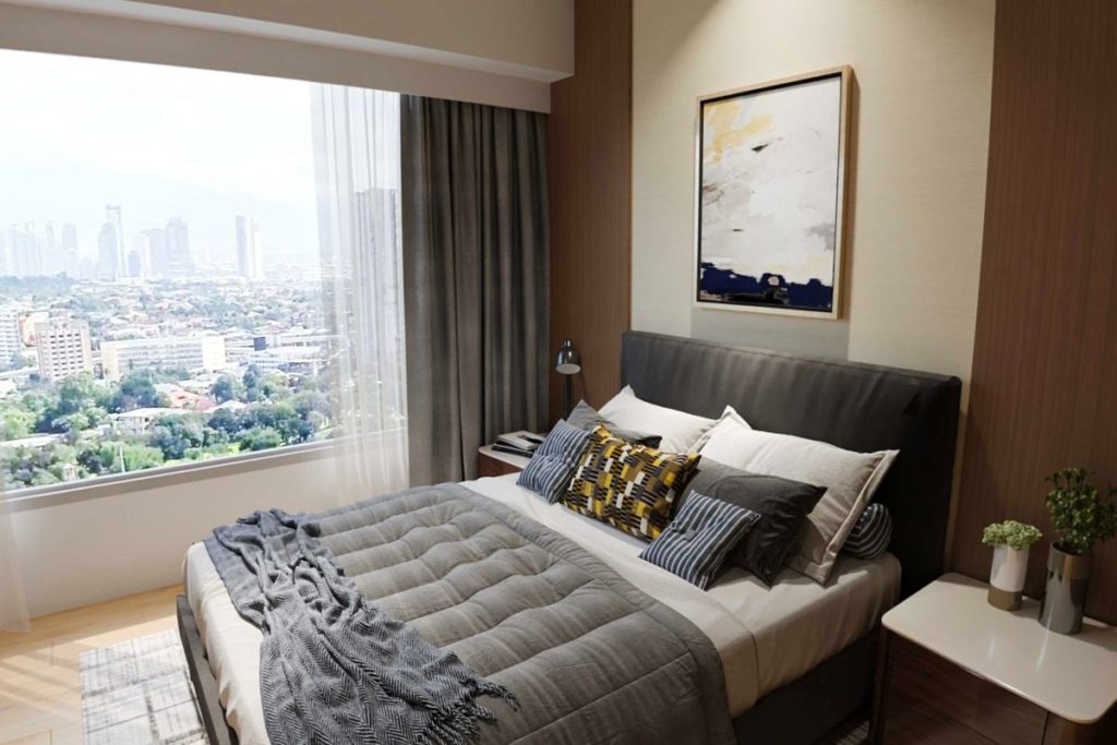 Modern condominium bedroom with large window overlooking the city skyline