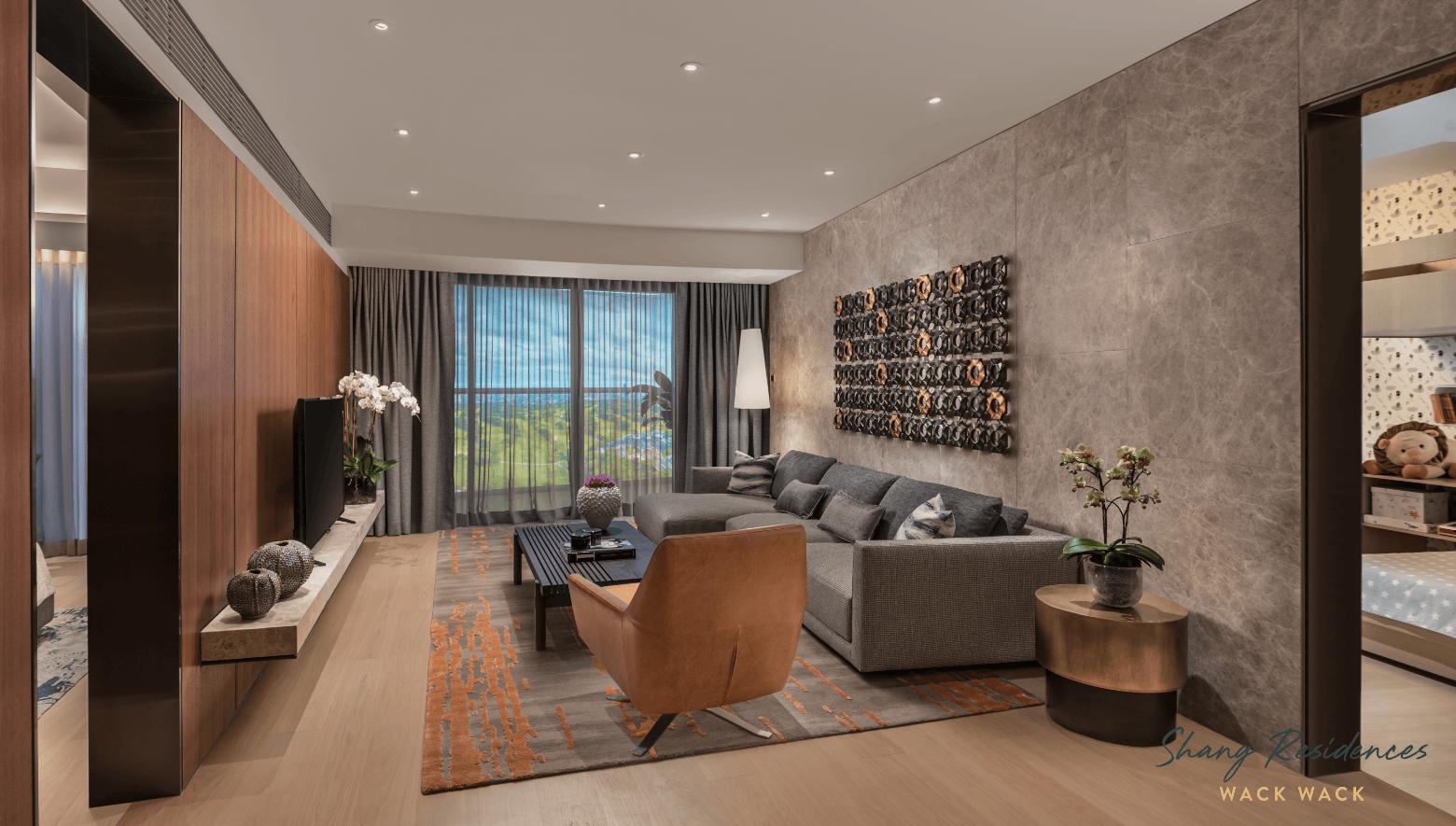 Elegant luxury condo living room with a gray sofa, wood finishes, city views, and refined décor at Shang Residences at Wack Wack
