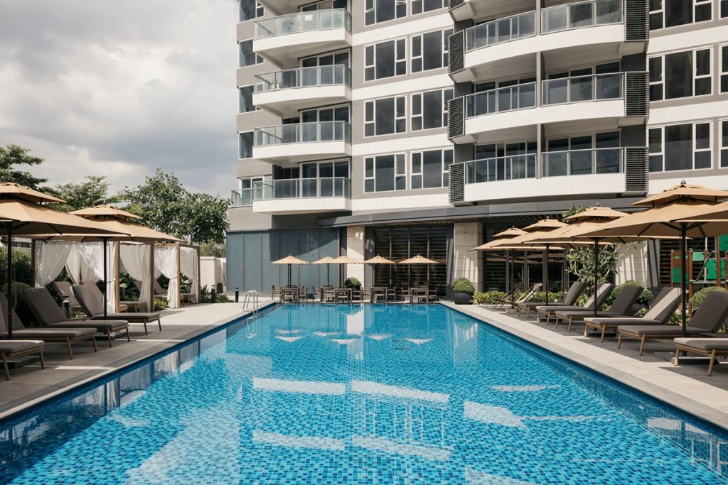 Resort-style swimming pool and outdoor lounge area at Shang Residences at Wack Wack, offering a relaxing environment for residents and families