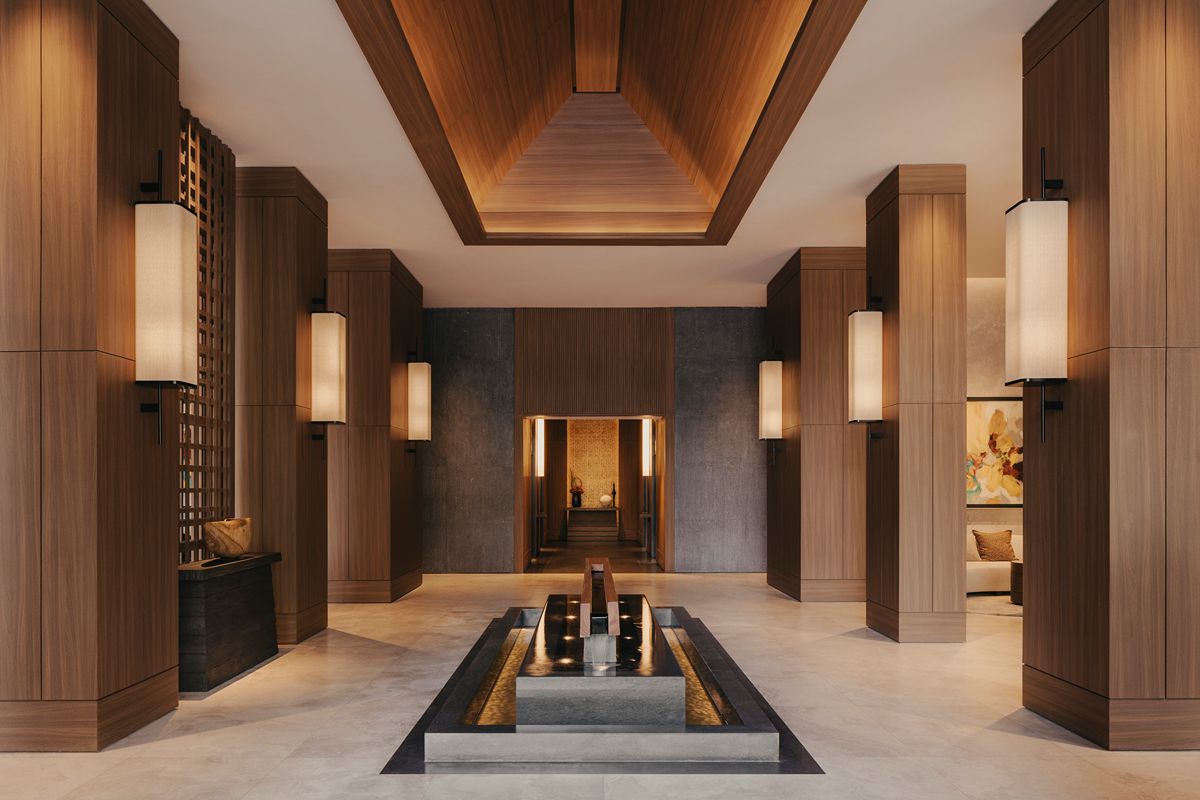 Elegant luxury condominium lobby in Mandaluyong featuring warm wood finishes, ambient lighting, and sophisticated interior design