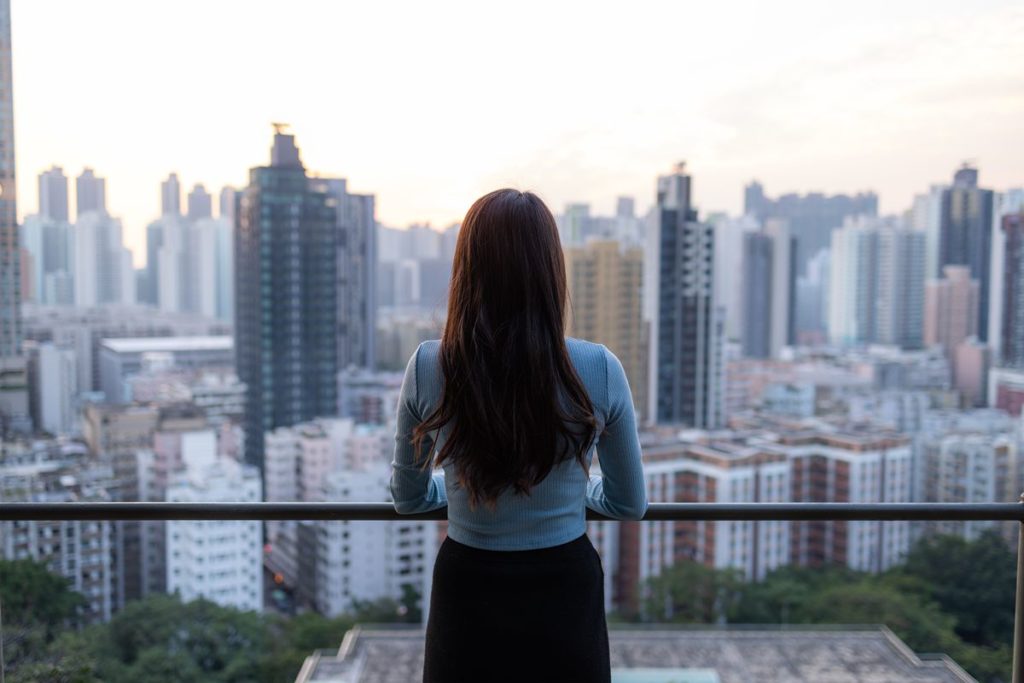 Woman overlooking the Metro Manila skyline, highlighting Mandaluyong’s central access to major business and lifestyle districts