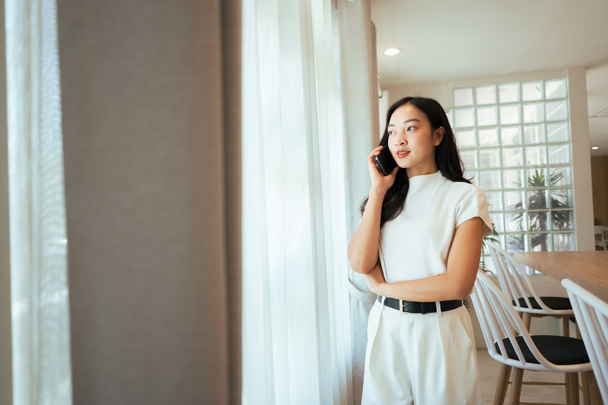 Woman standing inside a modern luxury residence, representing overseas buyers considering premium property in Mandaluyong